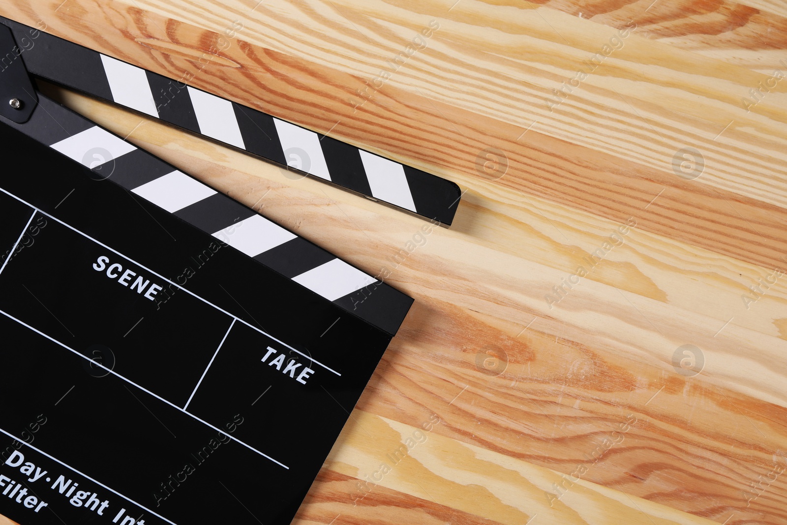 Photo of Clapperboard on wooden table, top view. Space for text