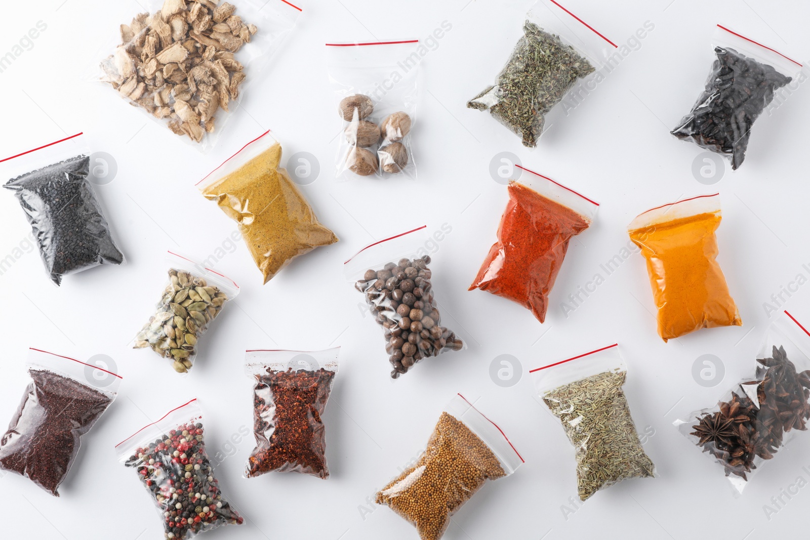 Photo of Plastic bags with different spices on white background, top view
