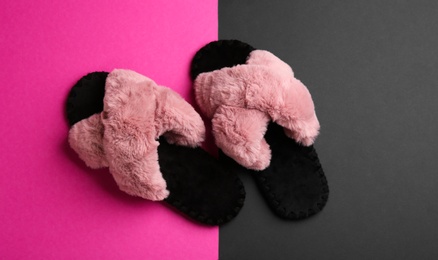 Pair of soft slippers on color background, flat lay