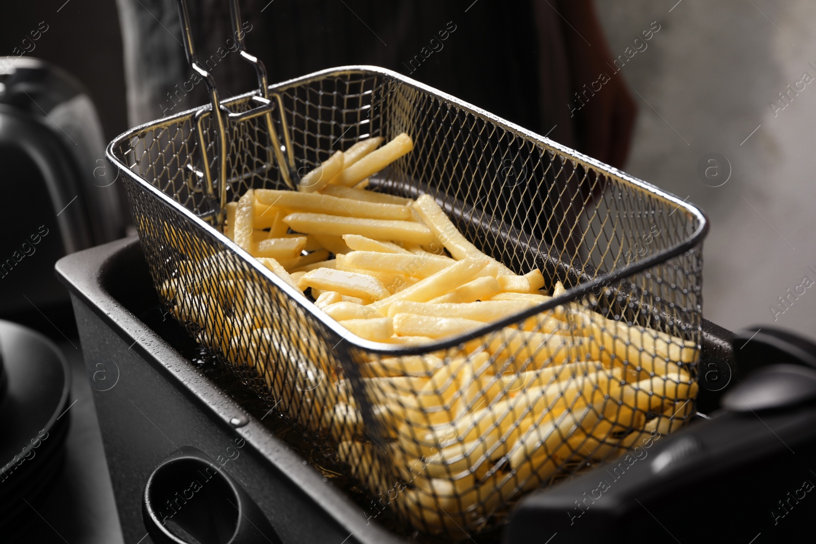 Photo of Cooking delicious french fries in hot oil