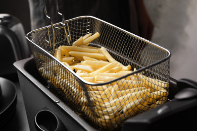 Photo of Cooking delicious french fries in hot oil
