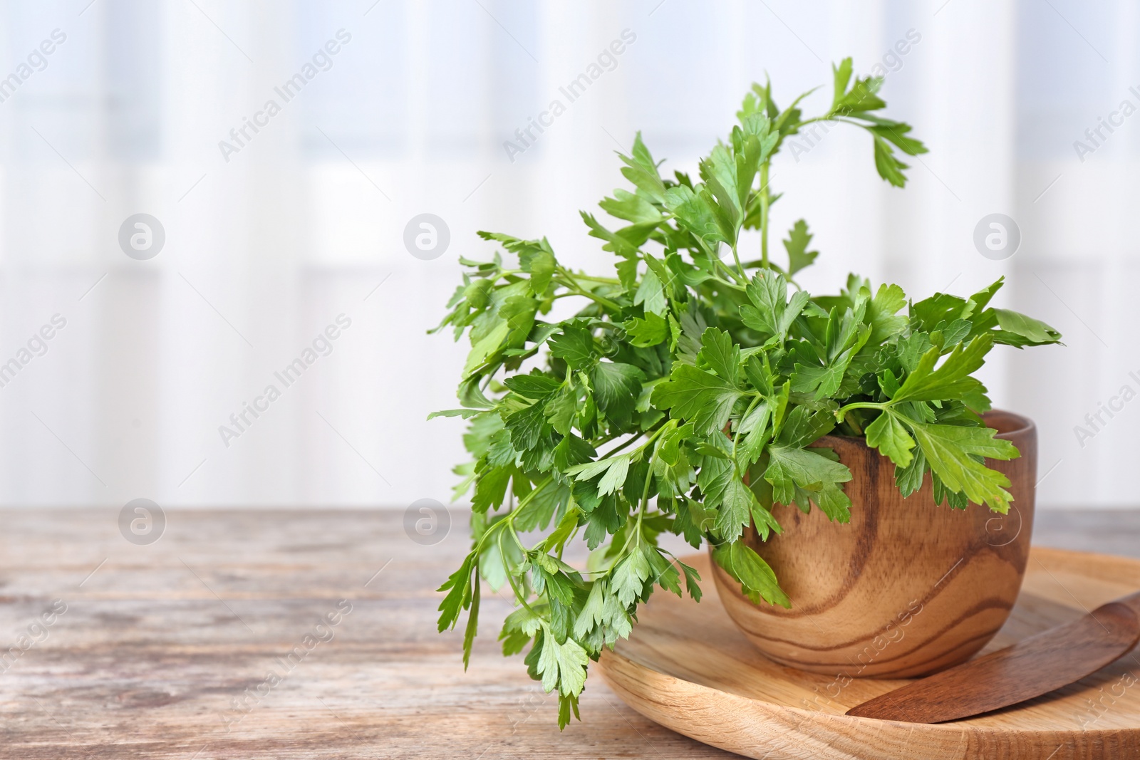 Photo of Bowl with fresh green parsley on table. Space for text