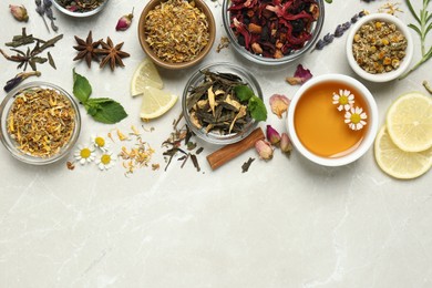 Flat lay composition with fresh brewed tea and dry leaves on light table, space for text