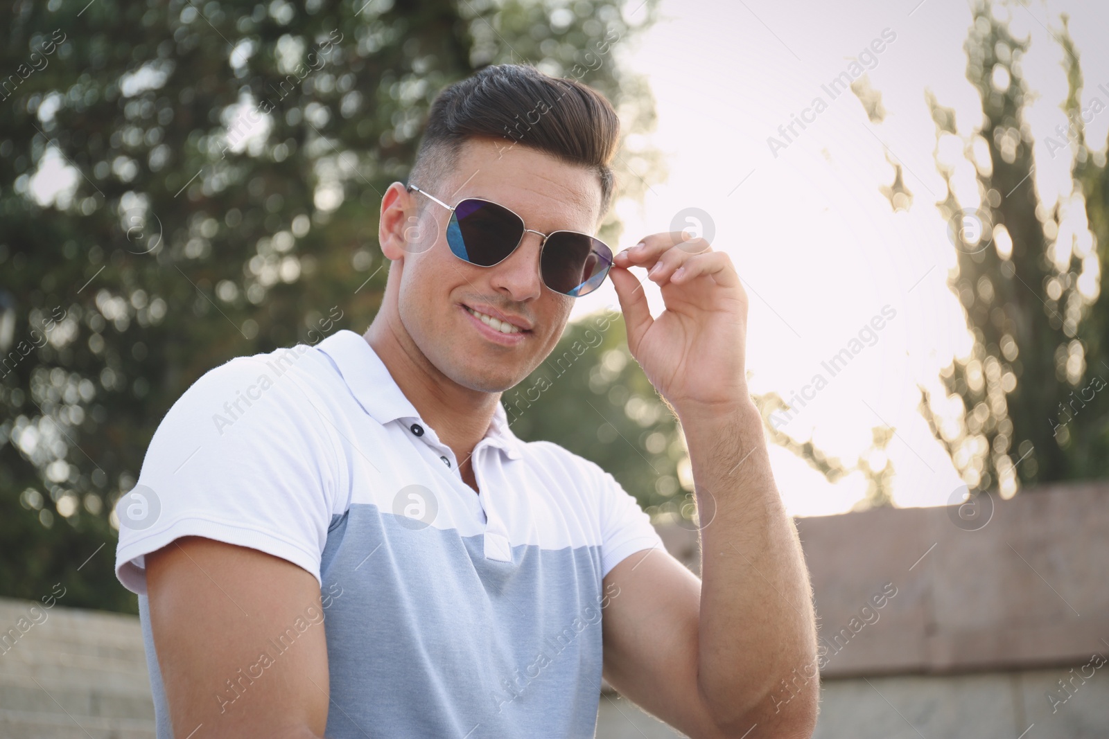 Photo of Handsome man wearing stylish sunglasses on city street