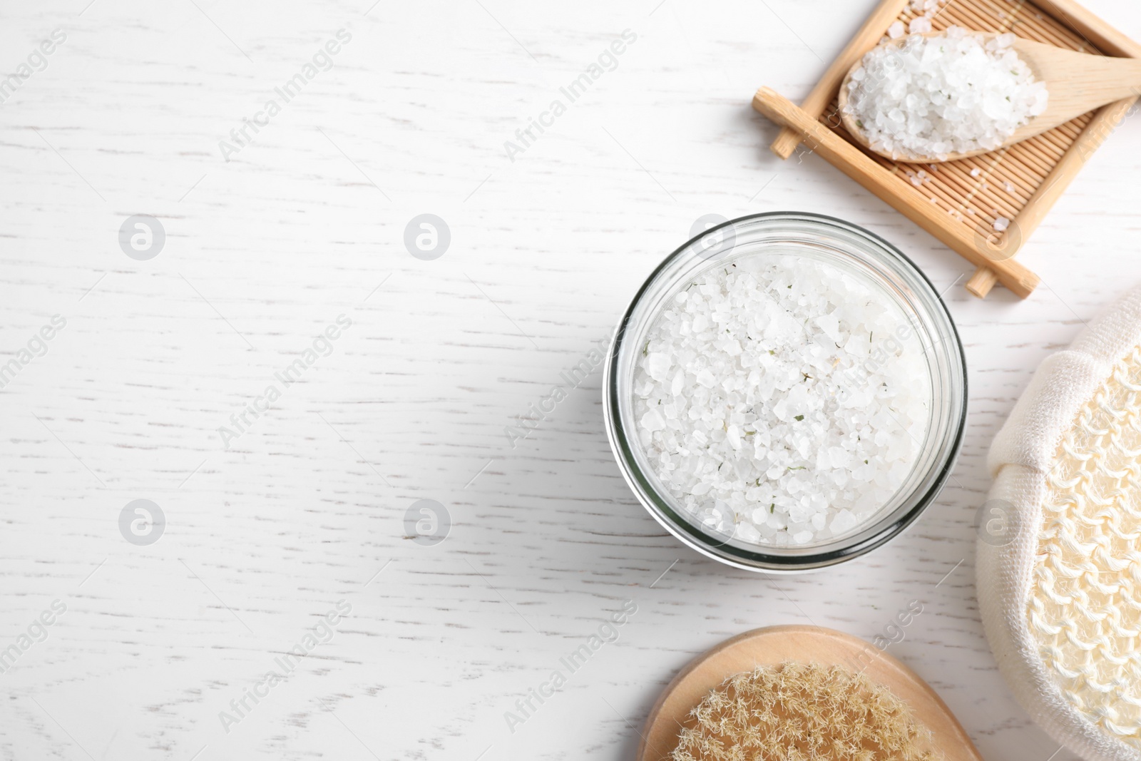 Photo of Sea salt for spa scrubbing procedure in jar on white wooden table, flat lay