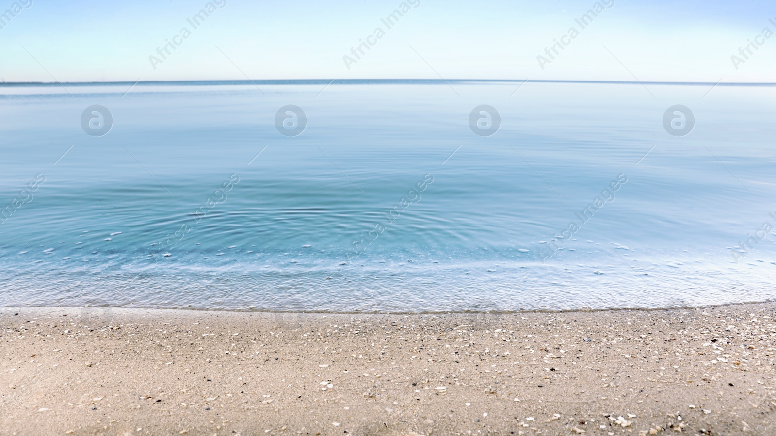 Photo of View of sea water and beach sand on sunny summer day