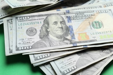 Photo of Many dollar banknotes on green background, closeup. American national currency