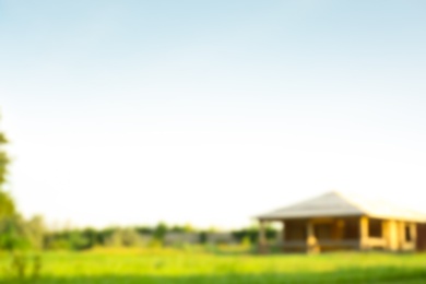 Photo of Blurred viewlandscape with meadow and building on sunny day