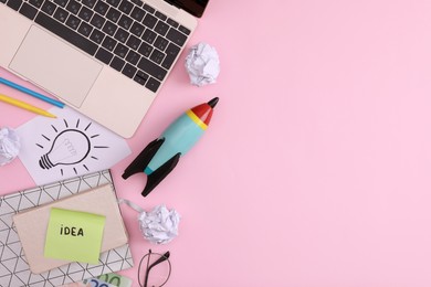 Photo of Flat lay composition with toy rocket, stationery and laptop on pink background, space for text. Startup concept