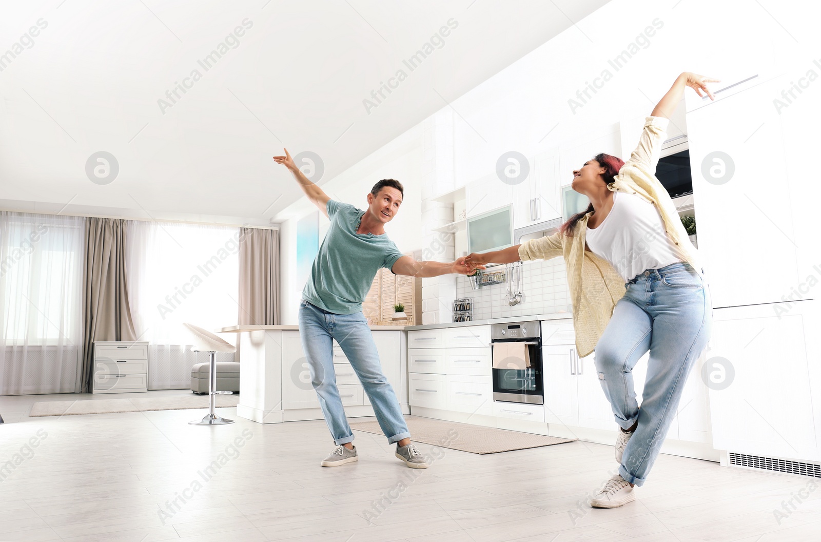 Photo of Beautiful couple dancing in kitchen at home