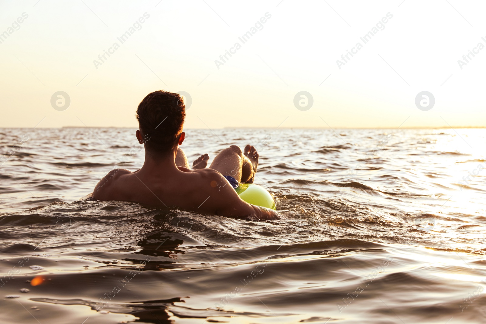 Photo of Young man with inflatable ring in sea