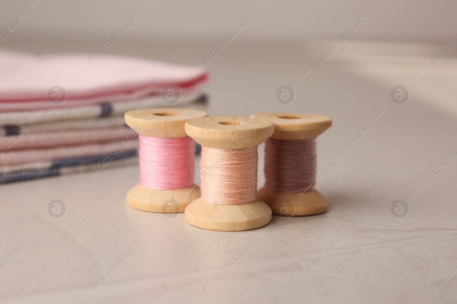 Photo of Set of color sewing threads on light grey table