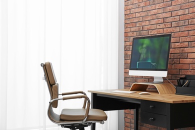 Photo of Stylish workplace interior with modern office chair