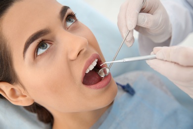 Photo of Dentist examining patient's teeth in modern clinic