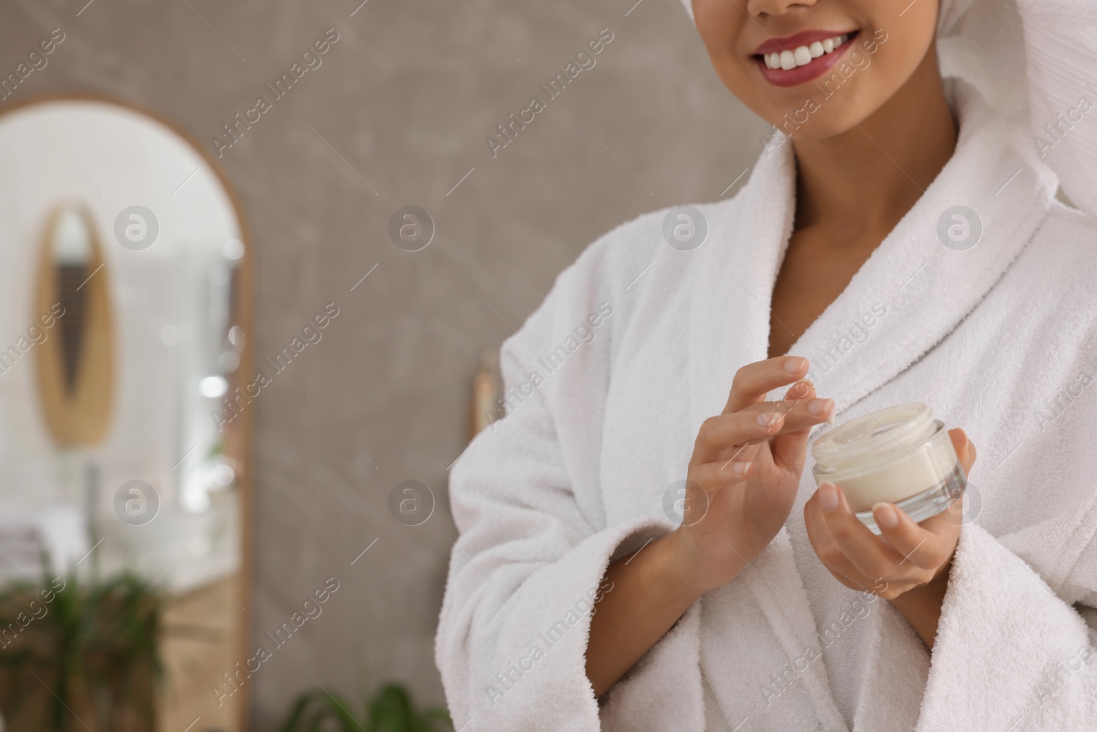 Photo of African American woman with jar of cream in bathroom, closeup. Space for text