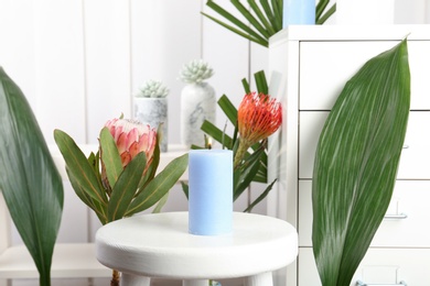 Photo of Creative composition with candle and tropical plants indoors