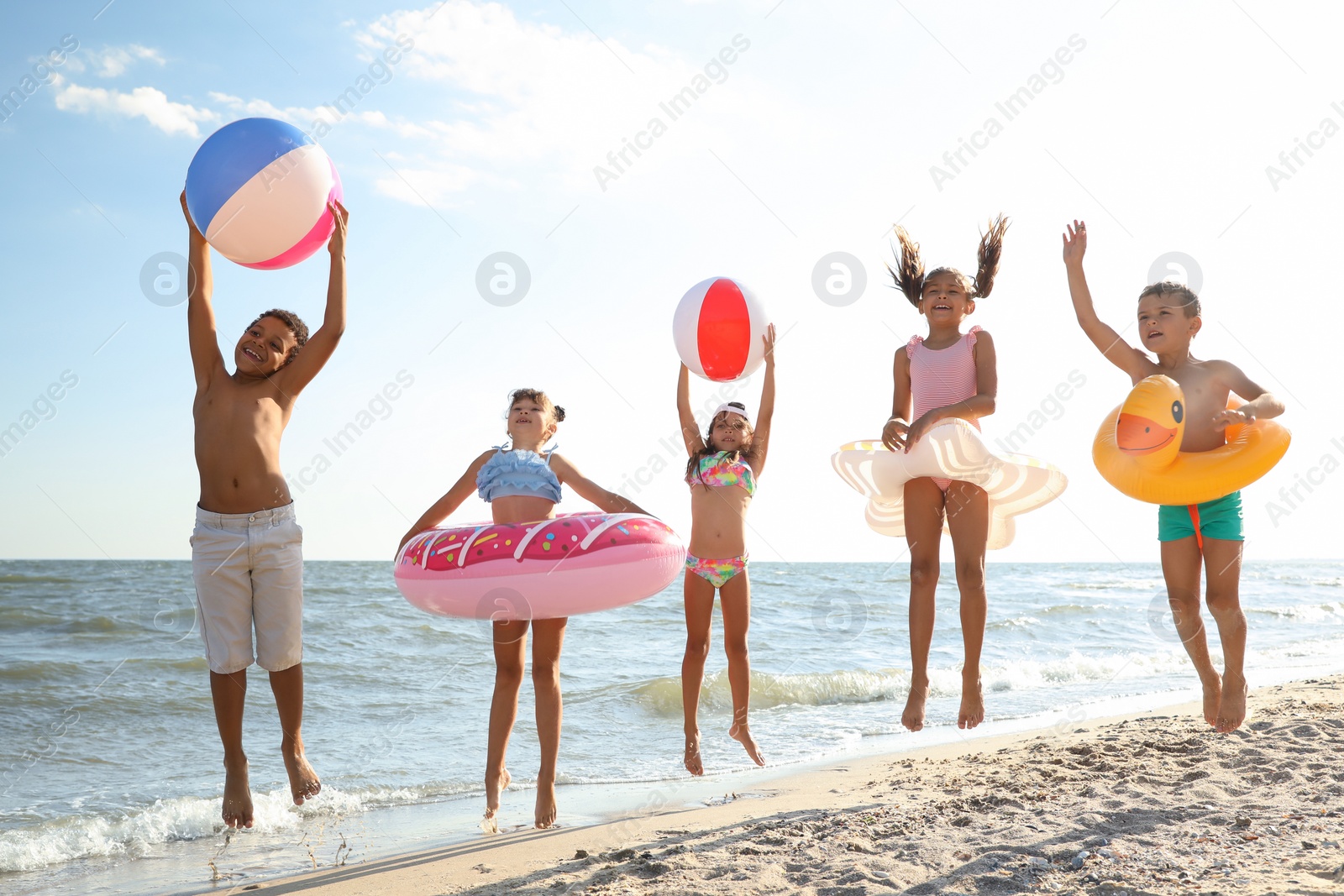 Photo of Cute children enjoying sunny day at beach. Summer camp