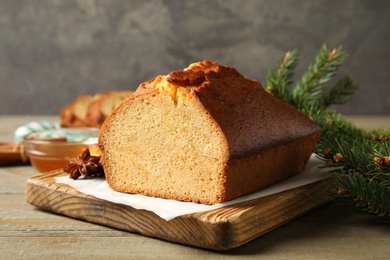 Delicious gingerbread cake and fir branch on wooden table