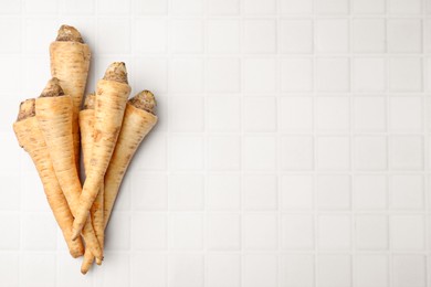 Raw parsley roots on white table, flat lay. Space for text