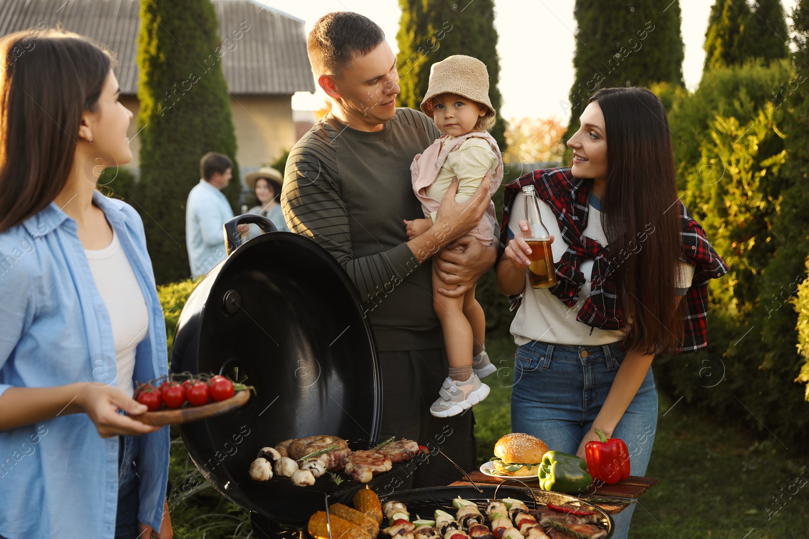 Photo of Family with friends having barbecue party outdoors