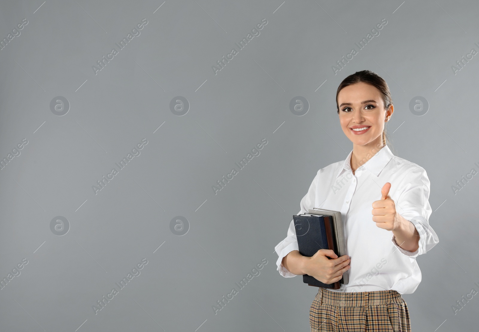 Photo of Portrait of young female teacher on grey background. Space for text