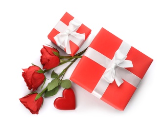 Photo of Beautiful gift boxes, roses and red heart on white background, top view. Valentine's day celebration