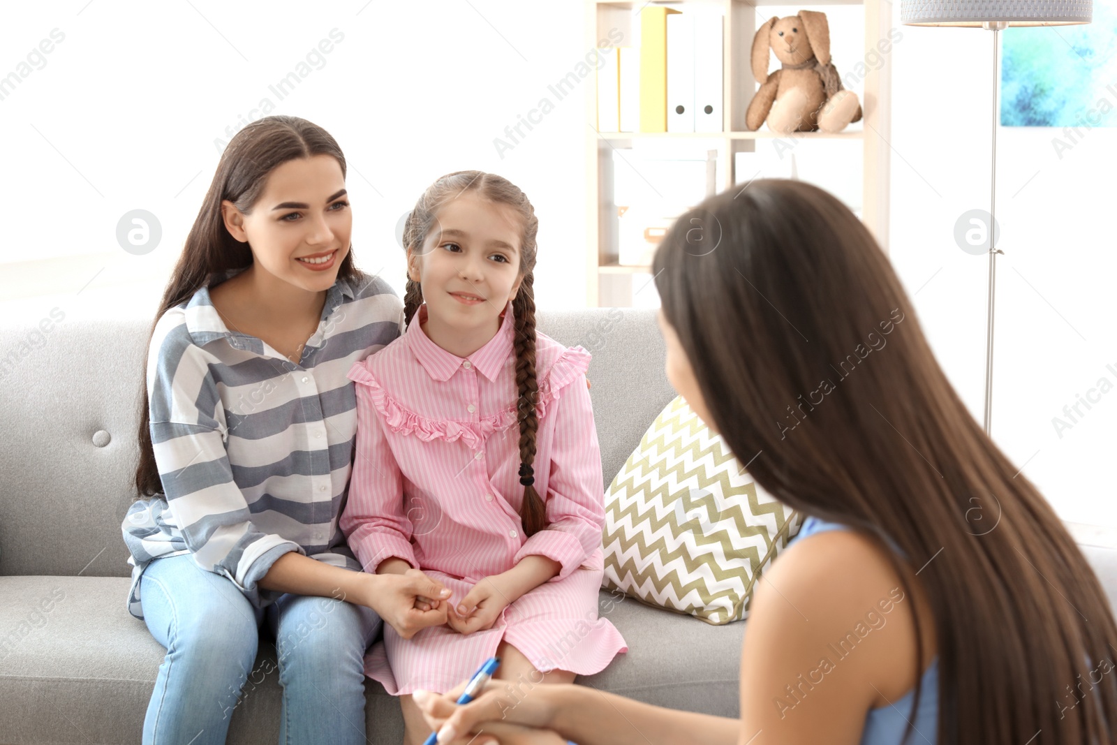 Photo of Young woman and her daughter having appointment with child psychologist in office