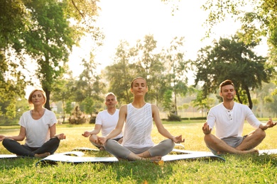 Photo of People practicing yoga in park at morning