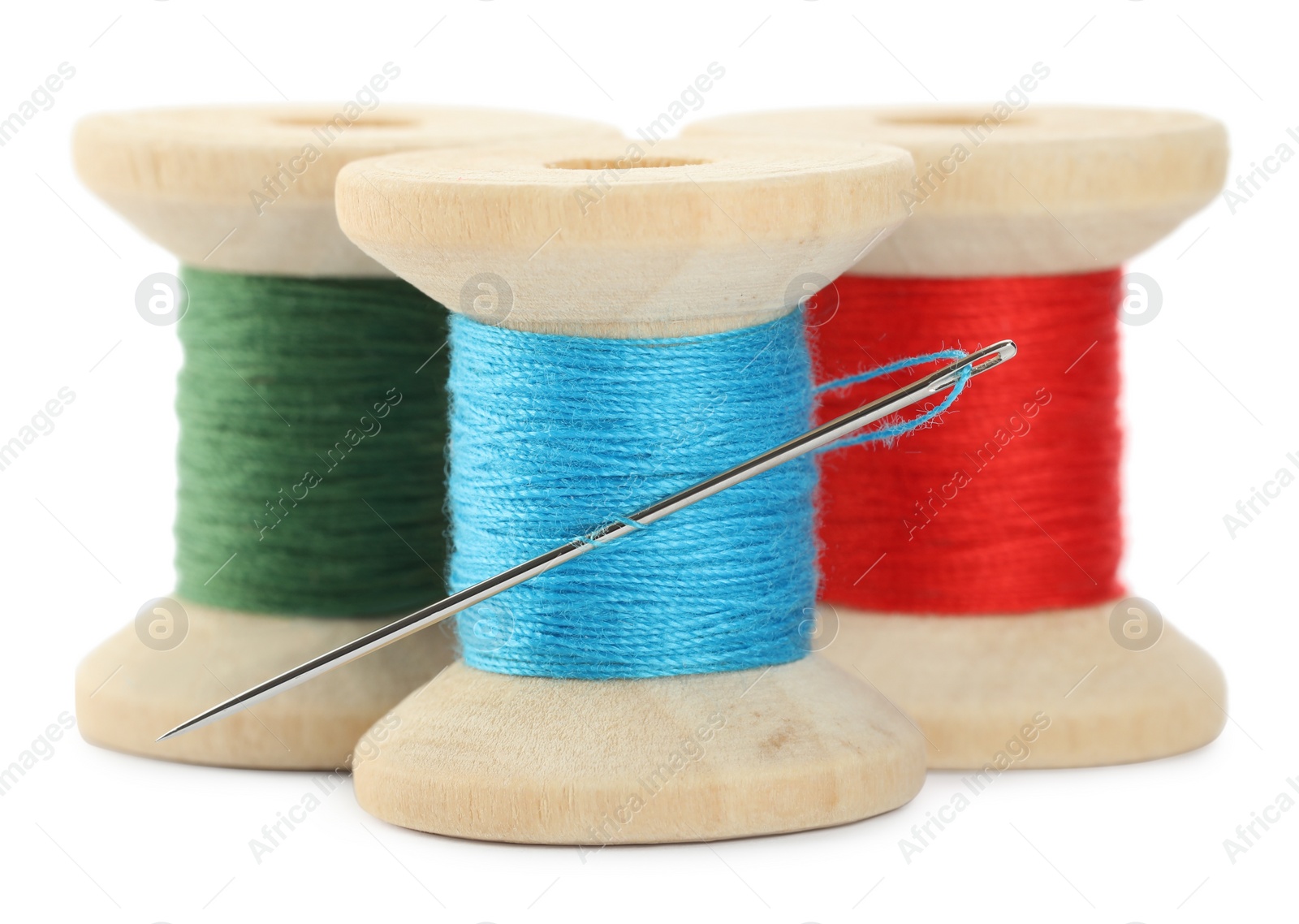 Photo of Different colorful sewing threads with needle on white background, closeup