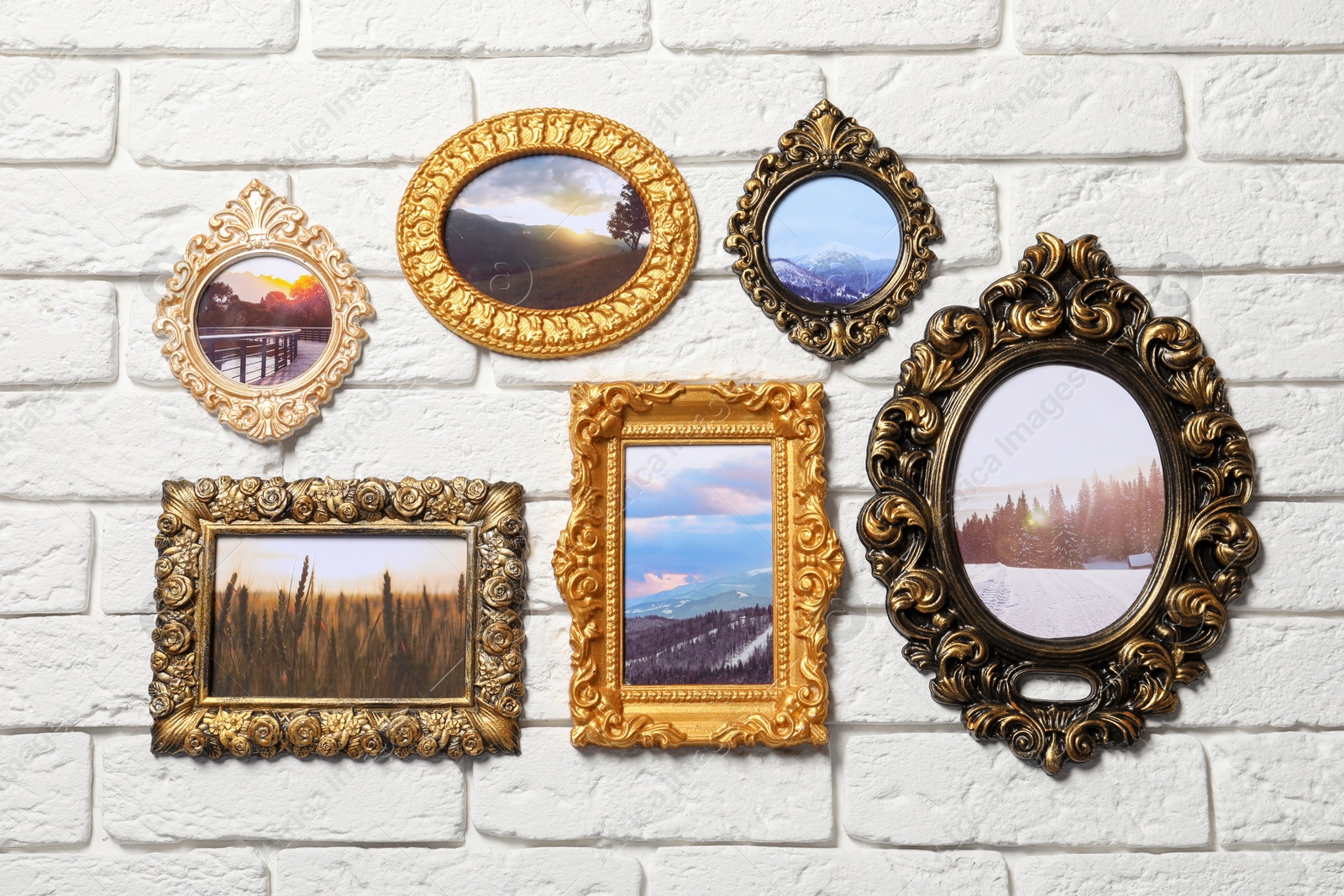 Photo of Vintage frames with photos of beautiful landscapes hanging on white brick wall