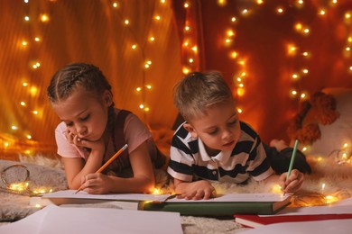 Children drawing in play tent at home