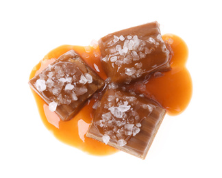 Photo of Delicious salted caramel with sauce on white background, top view