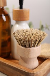 Photo of Cleaning brush and bottles on table, closeup