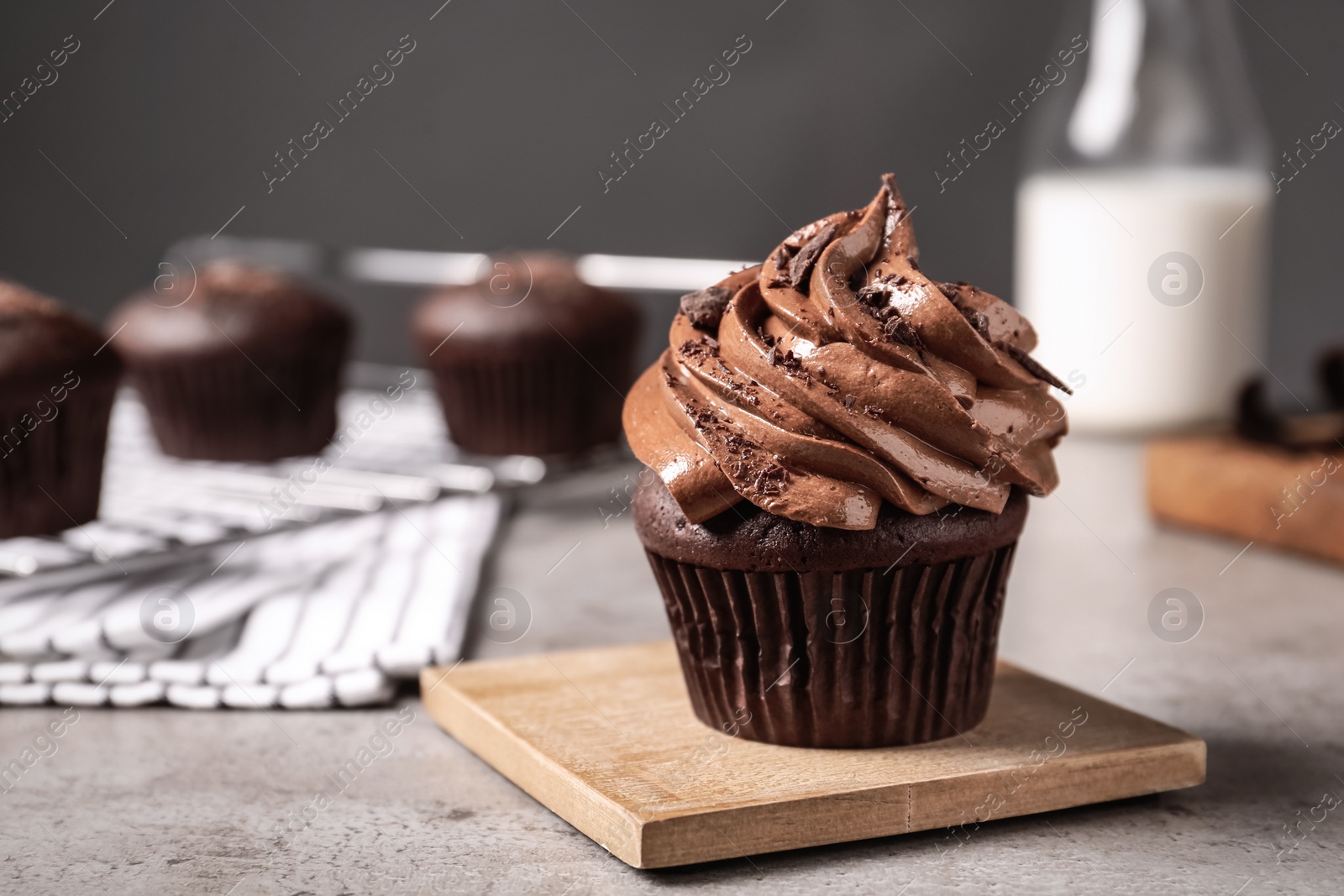 Photo of Delicious cupcake decorated with cream on grey table. Space for text