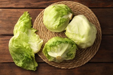 Fresh green iceberg lettuce heads and leaves on wooden table, flat lay