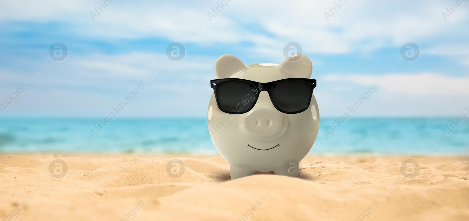 Image of Vacation savings. Piggy bank with sunglasses on sandy beach near sea, banner design