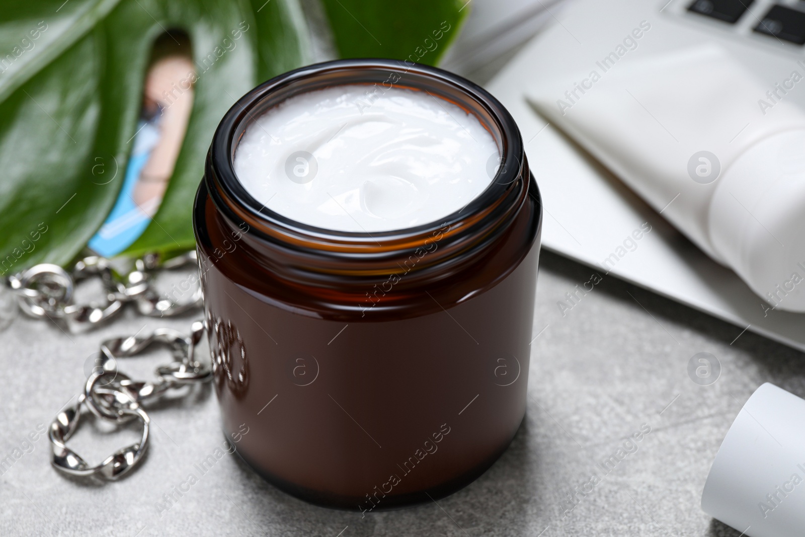 Photo of Jar of hand cream on light grey table, closeup