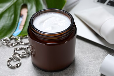 Photo of Jar of hand cream on light grey table, closeup