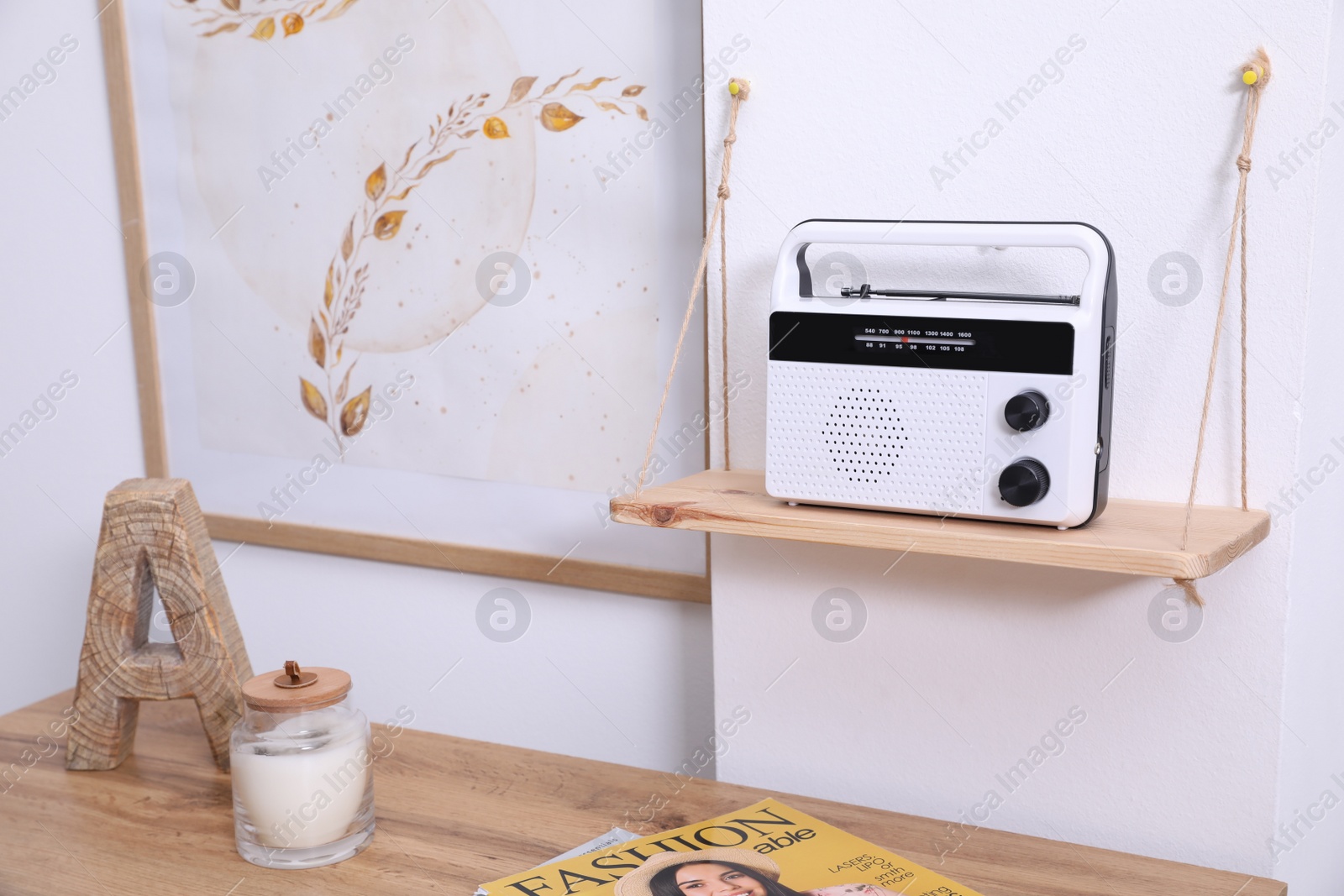 Photo of Wooden shelf with stylish radio on white wall indoors