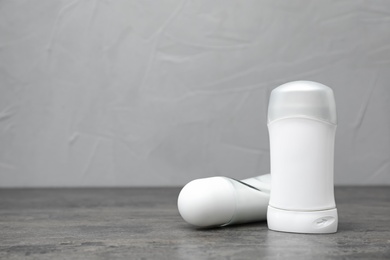 Photo of Deodorants on gray table against gray background. Skin care
