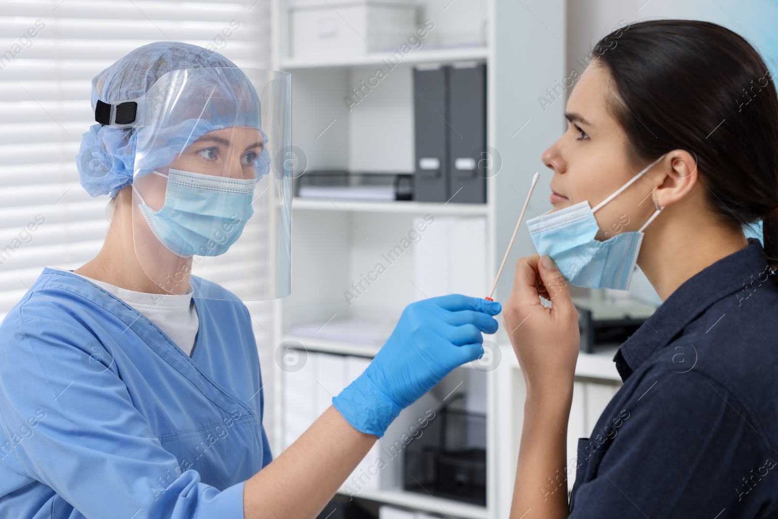 Photo of Laboratory testing. Doctor in uniform taking sample from patient's nose with cotton swab at hospital