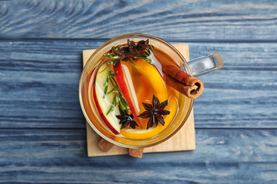 Aromatic mulled wine on blue wooden table, top view