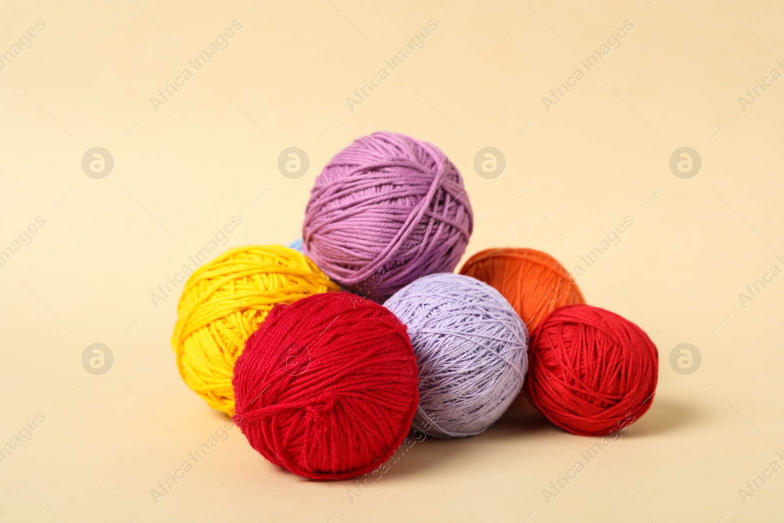 Photo of Soft colorful woolen yarns on beige background