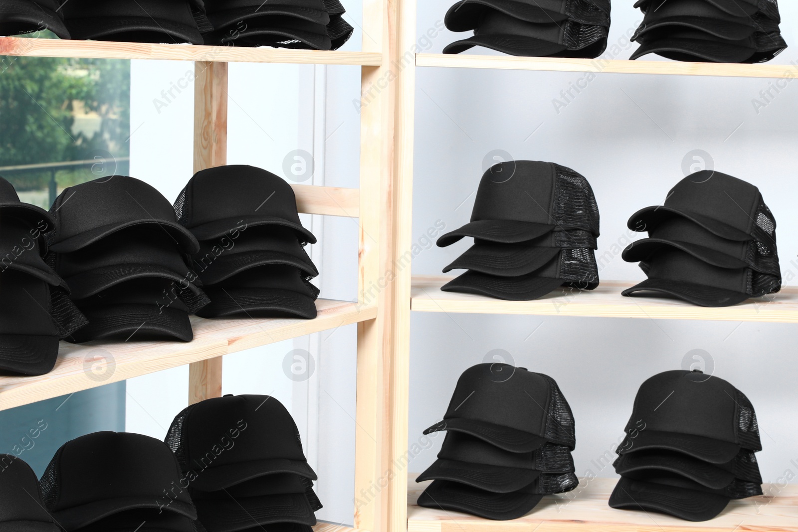 Photo of Wooden rack with blank black caps in store