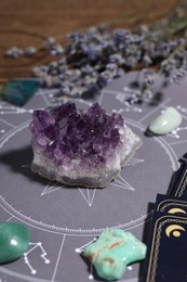 Photo of Astrology prediction. Zodiac wheel and gemstones on table, closeup