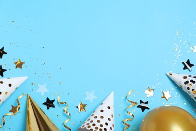 Photo of Flat lay composition with party hats, balloon and confetti on light blue background, space for text. Birthday decor