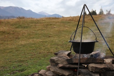 Cooking food on campfire in mountains. Camping season