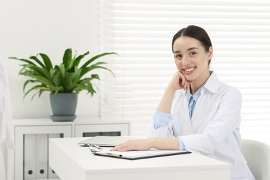 Photo of Medical consultant sitting at table in clinic