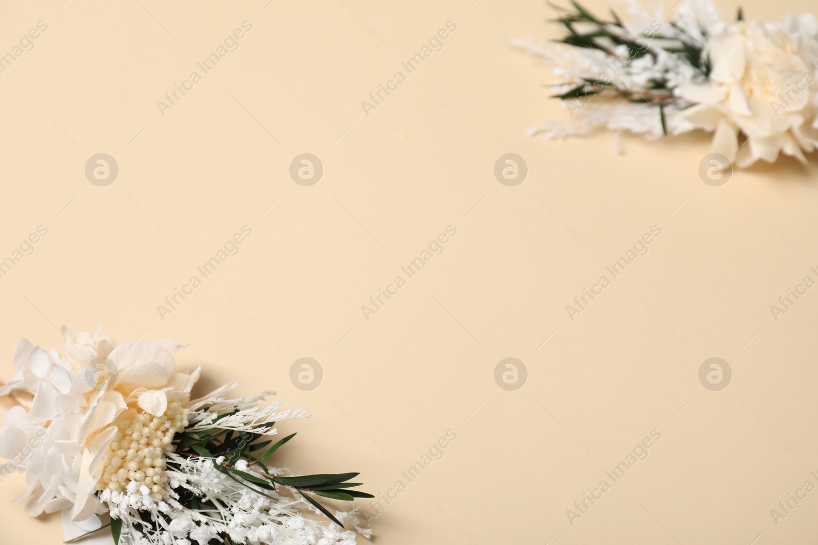 Photo of Stylish boutonnieres on beige background, closeup. Space for text