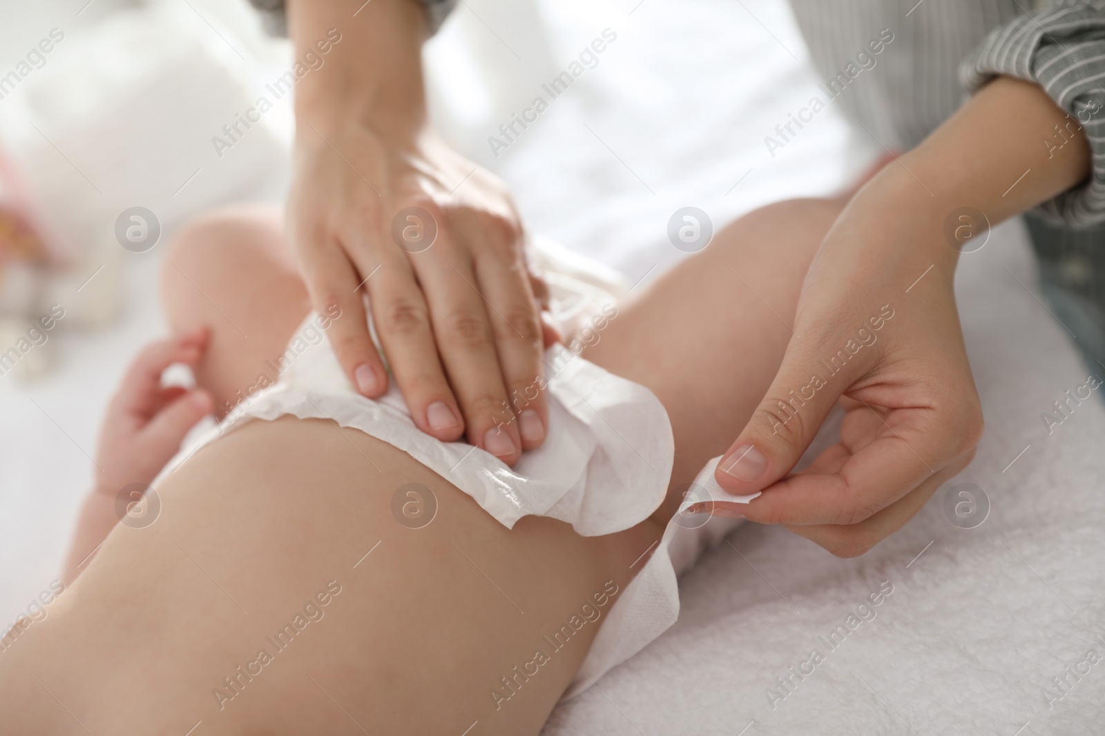 Photo of Mother changing her baby's diaper on table, closeup